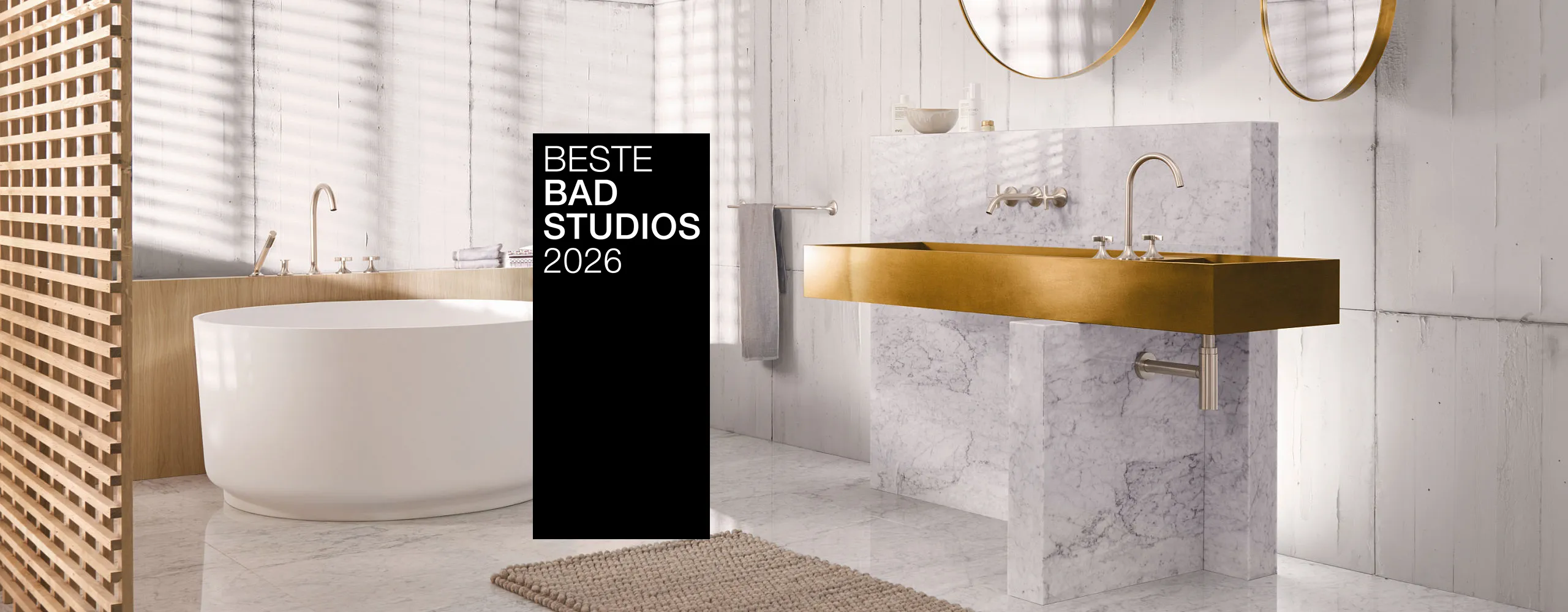 Ein stilvolles Bad mit goldenen Armaturen, Marmorwaschtisch und freistehender Badewanne. Ein schwarzer Banner mit "Beste Badstudios 2026" ist prominent im Bild.