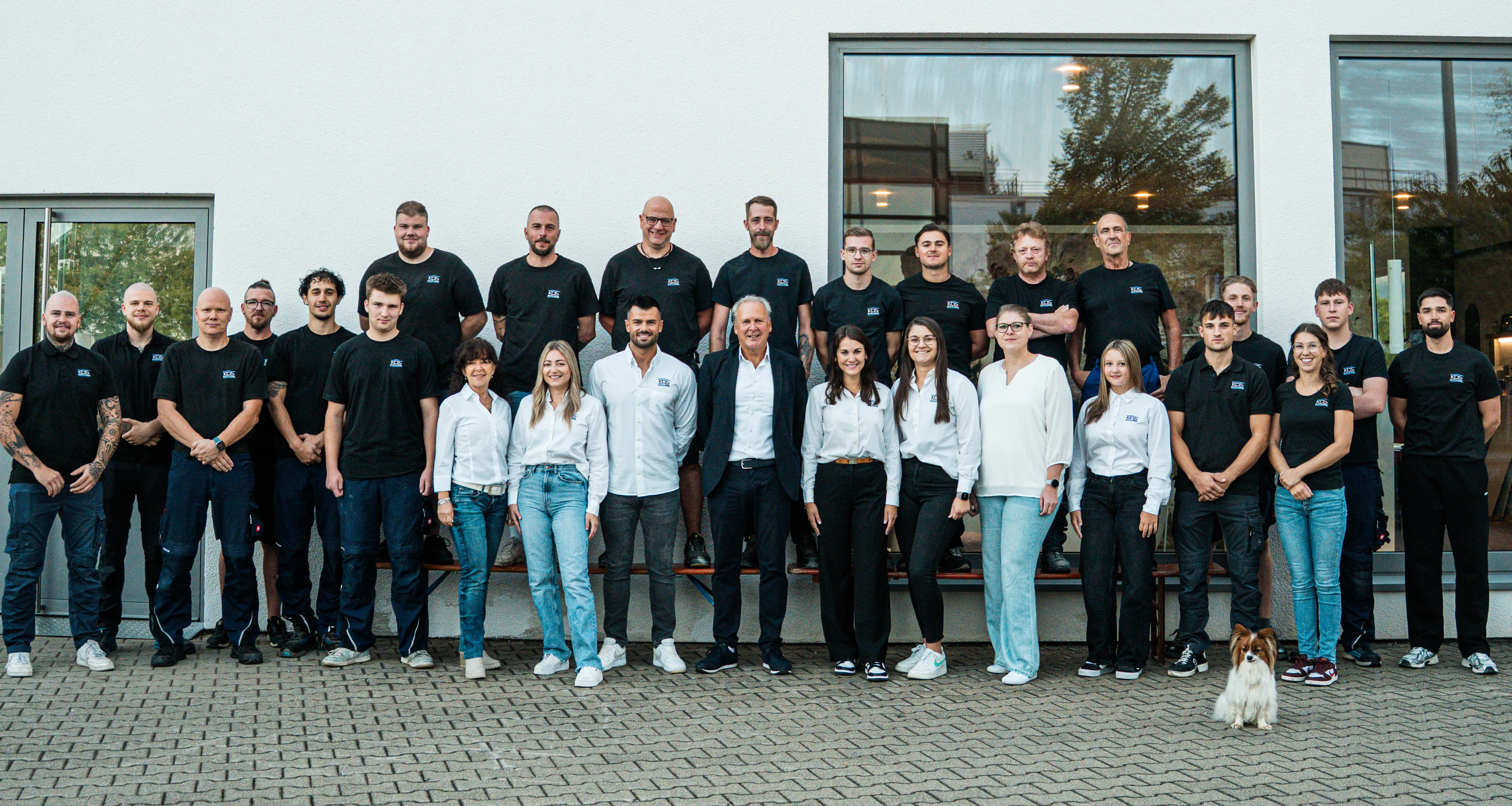 Gruppenfoto des gesamten Teams von KDS Haustechnik vor dem Firmengebäude mit dem Schriftzug KDS Bäder & Wärme.