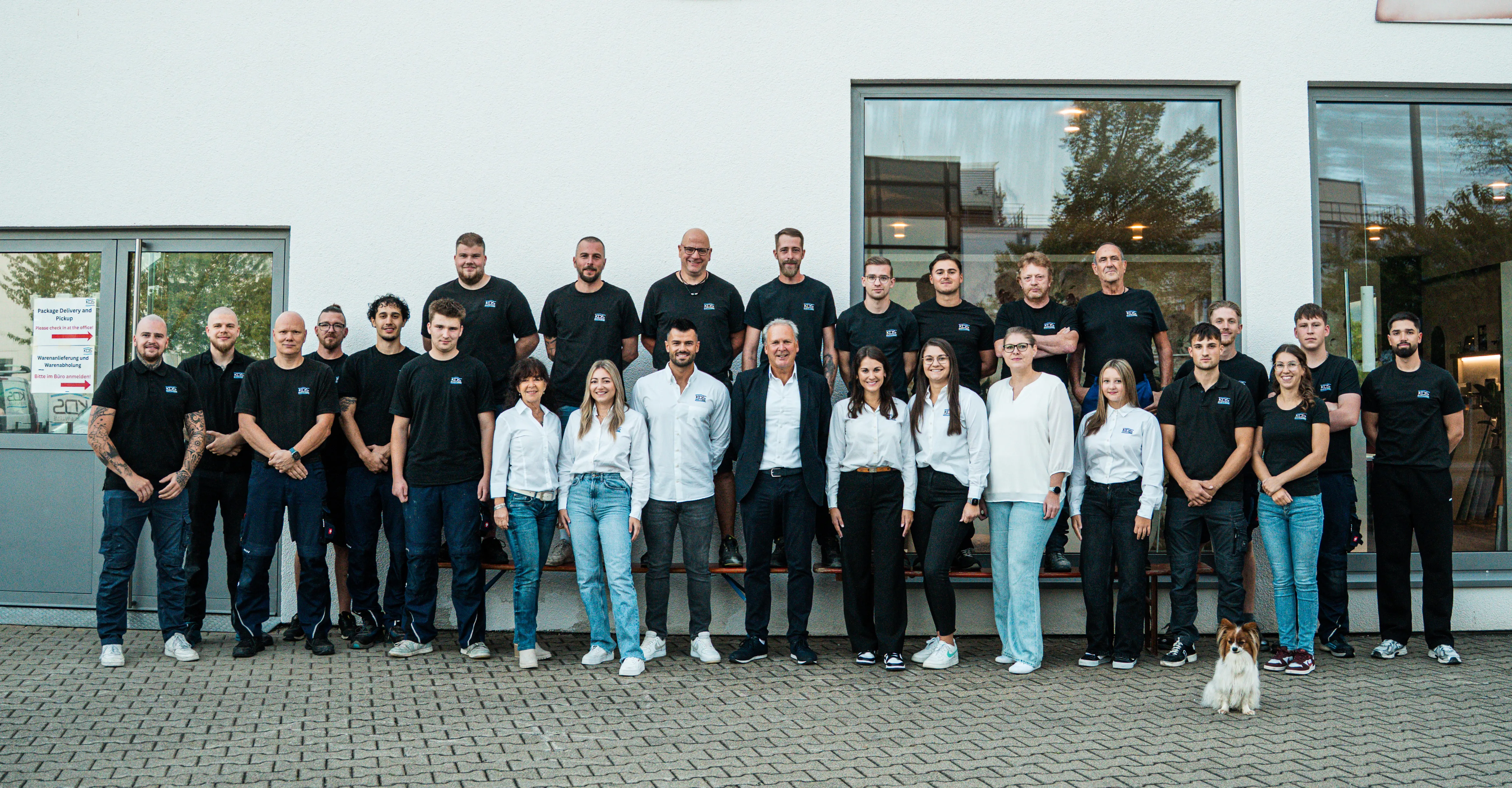 Gruppenfoto des gesamten Teams von KDS Haustechnik vor dem Firmengebäude mit dem Schriftzug KDS Bäder & Wärme.