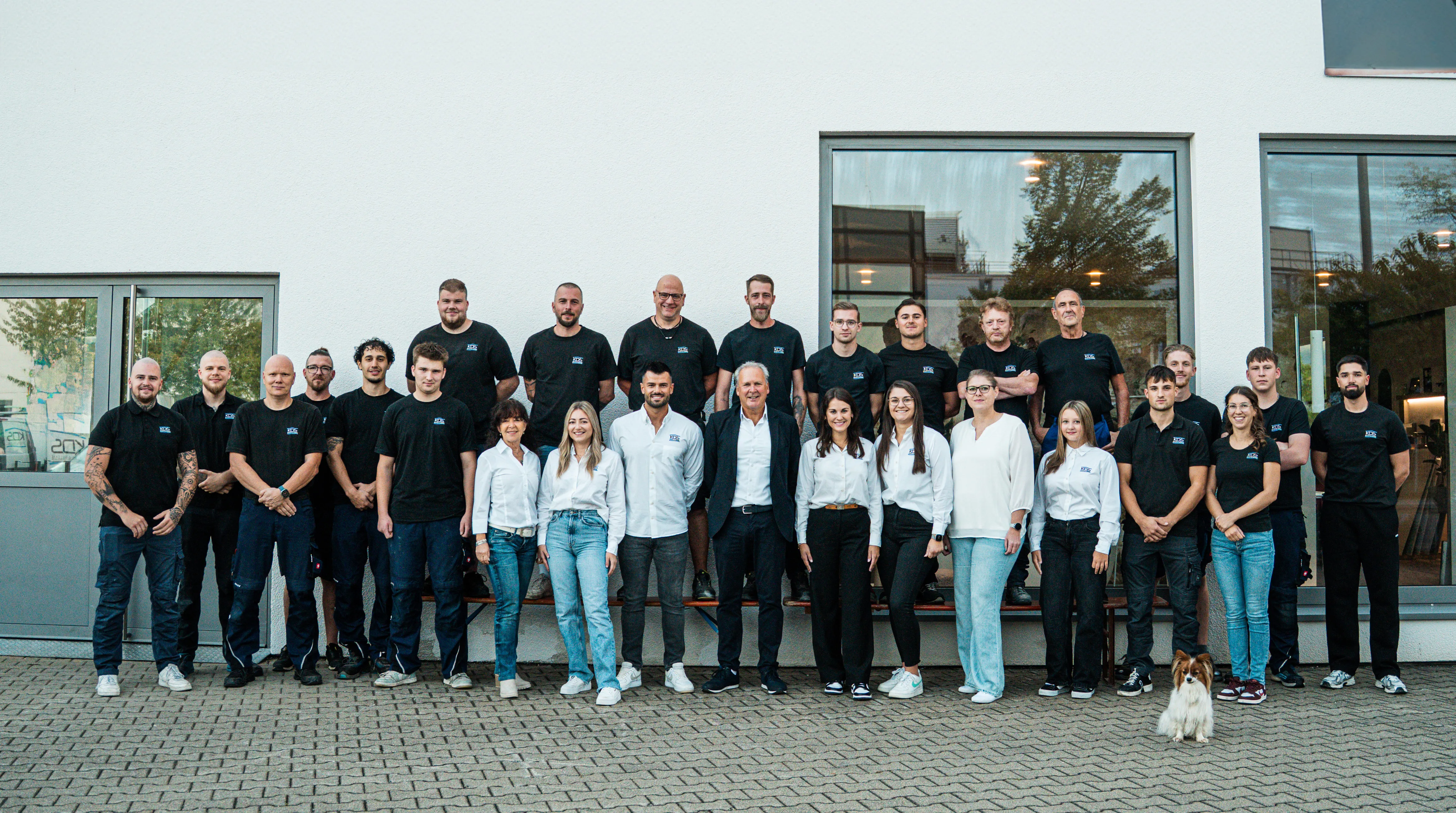 Gruppenfoto des gesamten Teams von KDS Haustechnik vor dem Firmengebäude mit dem Schriftzug KDS Bäder & Wärme.