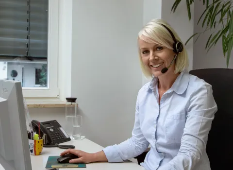 Bürokauffrau mit Headset in einem SHK-Handwerksbetrieb.