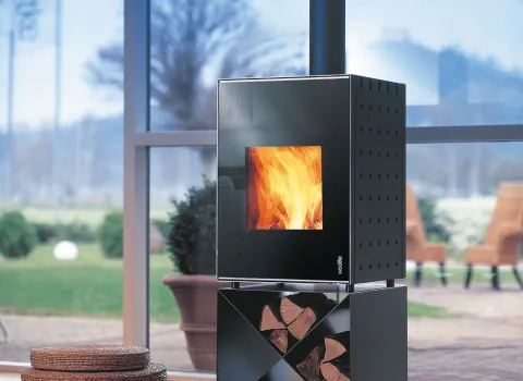 Kaminofen von Wodtke in einem Wohnzimmer mit großem bodentiefen Fenster zur Terrasse. 