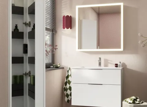 Ein moderner Waschtisch burgbad Eqio in glänzendem Weiß steht vor einer hellen Wand und wird von einem rechteckigen Spiegel RL20 mit umlaufender LED-Beleuchtung ergänzt.