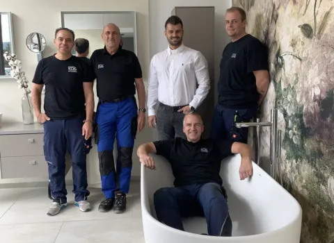 Das fünfköpfige Kundendienstteam von KDS-Haustechnik posiert in der Badausstellung.