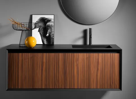 Moderner schwebender Waschtisch mit geriffelter Holzfront, schwarzer Waschtischplatte und integriertem Becken.