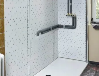 Badezimmer im Umbau: In der zuvor vorbereiteten Ecke ist nun eine große, weiße Duschwanne eingesetzt.