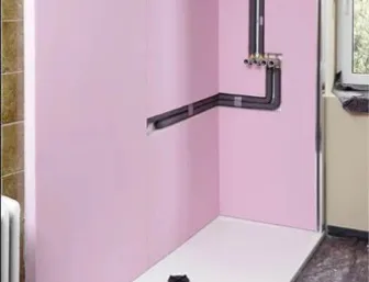 Badezimmer im Renovierungsprozess: Die zuvor montierten Bauplatten sind nun vollständig mit rosa Feuchtraumplatten verkleidet.