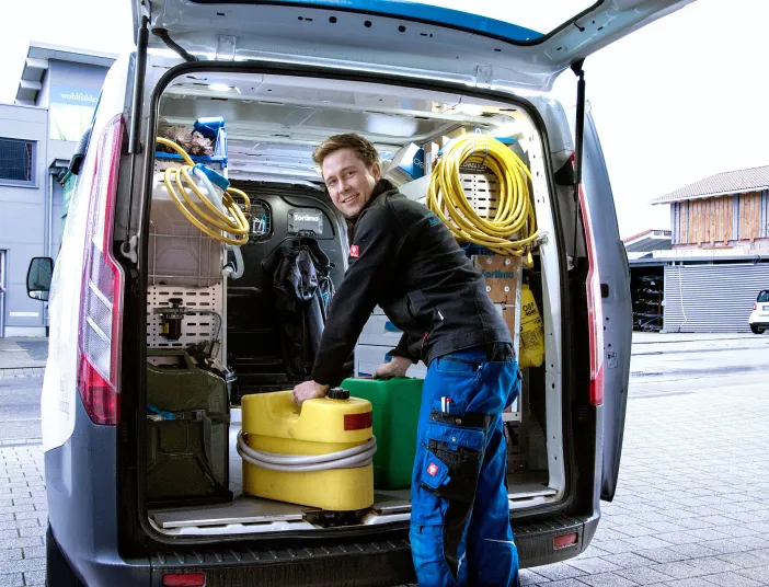 Kundendiensttechniker (SHK) vor Service-Fahrzeug.