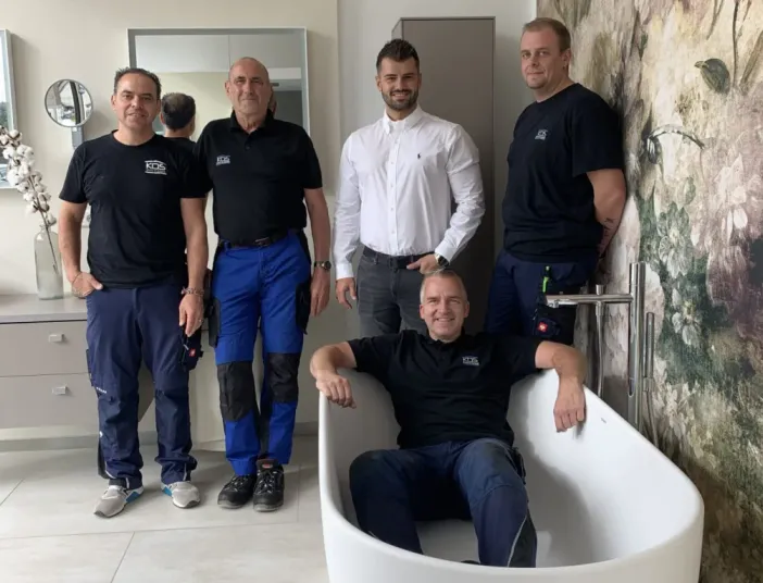 Das fünfköpfige Kundendienstteam von KDS-Haustechnik posiert in der Badausstellung.