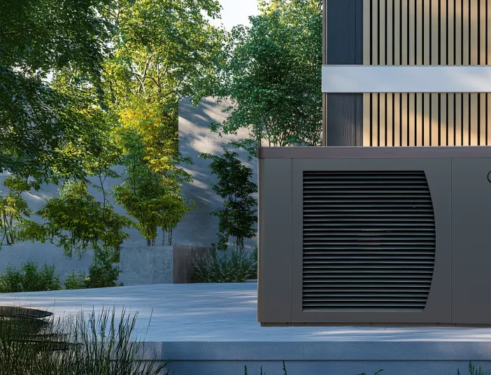 Eine Solvis-Wärmepumpe mit Lamellenfront steht auf einer Terrasse neben einem modernen Holzfassadenhaus, umgeben von Bäumen und Natur.