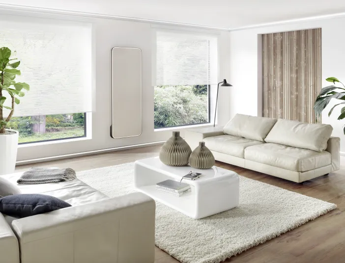 Weißer Designheizkörper Relax Hybrid vertikal im modernen Wohnzimmer mit LED-Rahmenbeleuchtung.